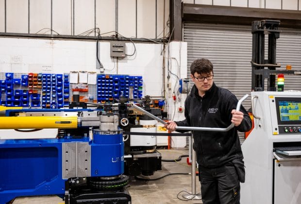 Engineer testing a bent tube on a Unison CNC tube bending machine